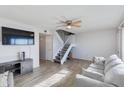 Bright living room featuring a ceiling fan, sleek floors, and stairway access to the second floor at 6351 N 49Th Ave, Glendale, AZ 85301