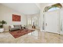 Inviting foyer with travertine flooring, arched doorway, and well-lit entry featuring a cozy seating area at 6828 E Evans Dr, Scottsdale, AZ 85254