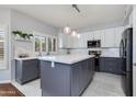 Modern kitchen with two-tone cabinetry, a center island, stylish pendant lighting, and stainless appliances at 7053 S Heather Dr, Tempe, AZ 85283