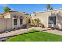 Inviting home exterior featuring a well-manicured lawn, desert landscaping, and a charming covered entrance at 7168 N Via De Amigos --, Scottsdale, AZ 85258