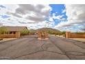 Gated community entrance with stone pillars, desert landscaping, blue sky and cloud background on a sunny day at 8474 W Switchback Trl, Casa Grande, AZ 85194