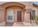 Close-up of front door with sidelight windows and desert landscaping at 9706 E Sheena Dr, Scottsdale, AZ 85260