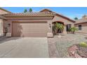Inviting home with a well-maintained two-car garage and desert-style landscaping at 9706 E Sheena Dr, Scottsdale, AZ 85260