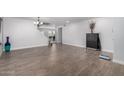 Open living area with neutral walls, wood-look tile flooring, stairs leading upstairs, and a modern light fixture at 10865 E Florian Ave, Mesa, AZ 85208