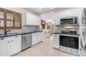 Bright kitchen featuring stainless steel appliances, white cabinets, black countertops, and views into the living room at 1285 E Cottonwood Rd, San Tan Valley, AZ 85140