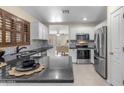 Well-lit kitchen featuring stainless steel appliances, white cabinets, black countertops, and views into the living room at 1285 E Cottonwood Rd, San Tan Valley, AZ 85140