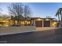 Inviting single-story home with a two-car garage, desert landscaping, and unique architectural details at 1422 E Royal Palm Rd, Phoenix, AZ 85020