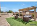 Relaxing outdoor living space with pergola, lounge seating, fire pit, and manicured landscaping at 3005 W Donatello Dr, Phoenix, AZ 85086