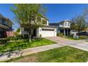 Two-story home featuring a brick driveway, two car garage, lush lawn, and vibrant landscaping at 3028 E Austin Dr, Gilbert, AZ 85296