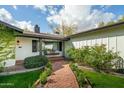 Charming home featuring a cozy porch swing, brick walkway, and lush landscaping at 4331 E Avalon Dr, Phoenix, AZ 85018