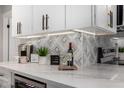 Kitchen counter featuring marble countertops, designer backsplash, and elegant decor at 5022 E Magic Stone Dr, Phoenix, AZ 85044