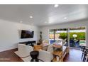 Bright living room with recessed lighting, stylish seating, and sliding glass doors opening to an outdoor pool area at 5110 E Verde Ln, Phoenix, AZ 85018
