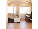 Bright living room with neutral furniture, tile flooring, and a view into the dining area at 7024 W Tether Trl, Peoria, AZ 85383