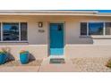 Charming home featuring a turquoise front door, colorful potted plants, and well-maintained landscaping at 7526 E Mckinley St, Scottsdale, AZ 85257