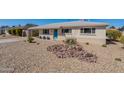 Inviting home exterior featuring desert landscaping, a carport, and a vibrant turquoise front door at 7526 E Mckinley St, Scottsdale, AZ 85257