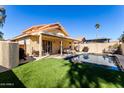 Beautiful backyard with a refreshing pool, covered patio, lush artificial grass, and outdoor grilling area at 8807 E Dahlia Dr, Scottsdale, AZ 85260