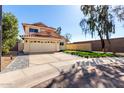 Charming two-story home with a red tile roof, a spacious driveway, and desert landscaping at 8807 E Dahlia Dr, Scottsdale, AZ 85260