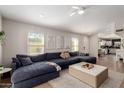 Bright living room with wood floors, a large couch, and a ceiling fan at 8807 E Dahlia Dr, Scottsdale, AZ 85260