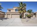 Inviting two-story home with a three-car garage, desert landscaping, and large palm tree at 9058 E Pine Valley Rd, Scottsdale, AZ 85260