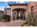 Inviting front entrance featuring a carved door, stone accents, and desert landscaping at 9920 E Honey Mesquite Dr # 155, Scottsdale, AZ 85262
