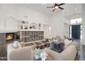 Bright living room features a cozy fireplace, soaring ceilings, custom built-ins, and sophisticated neutral decor at 10290 N 117Th Pl, Scottsdale, AZ 85259
