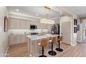 Modern kitchen with marble countertops, tiled backsplash, and seating at the kitchen island at 12860 W Junipero Dr, Sun City West, AZ 85375