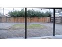 View from covered patio to the expansive backyard with gravel and block perimeter fence at 2215 W Highland Ave, Phoenix, AZ 85015