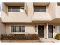 Townhome exterior showcasing beige stucco, multi-pane windows, and a covered front entryway at 2221 W Farmdale Ave # 7, Mesa, AZ 85202