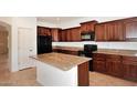 Cherry wood kitchen with granite countertop island and black appliances at 24113 N 26Th Pl, Phoenix, AZ 85024