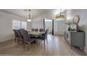 Dining room features hardwood floors, neutral walls, a modern chandelier, and a dining table with upholstered chairs at 2414 W White Feather Ln, Phoenix, AZ 85085