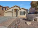 Single-story home featuring a two-car garage, desert landscaping, and a brick walkway to the front door at 2414 W White Feather Ln, Phoenix, AZ 85085