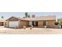 Charming single story brick home featuring a well-manicured front yard with desert landscaping and a two car garage at 3147 W Phelps Rd, Phoenix, AZ 85053