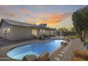 Backyard pool with rock landscaping and outdoor dining area offers a tranquil setting at 3325 N Desoto St, Chandler, AZ 85224