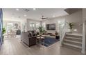 Open-concept living room featuring a large TV, modern furnishings, and a staircase leading to the upper level at 4832 S Ferric --, Mesa, AZ 85212