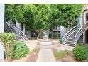 Beautiful courtyard featuring mature trees, a decorative fountain, and walkways to building access points at 5211 N 24Th St # 104, Phoenix, AZ 85016