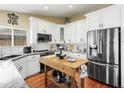 Modern kitchen featuring white cabinets, stainless steel appliances, granite countertops and a butcher block island at 8354 W Surrey Ave, Peoria, AZ 85381