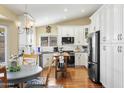 Bright kitchen with white cabinets, granite countertops, stainless steel appliances, and hardwood floors at 8354 W Surrey Ave, Peoria, AZ 85381