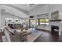 Open-concept living room with vaulted ceilings, fireplace, and natural light from large windows at 9422 E Southwind Ln, Scottsdale, AZ 85262