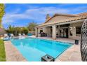 Resort-style pool with luxurious lounge chairs, outdoor grilling area and covered patio at 9422 E Southwind Ln, Scottsdale, AZ 85262