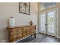 Inviting foyer with decorative glass double doors and wood-look flooring and an ornate console table at 9535 E Los Lagos Vista Ave, Mesa, AZ 85209