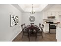 Traditional dining room with wooden table, chairs, chandelier, and stainless steel appliances at 10610 S 48Th St # 1068, Phoenix, AZ 85044