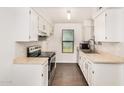 Well-lit kitchen with white cabinetry, neutral countertops, stainless steel appliances, and a window at 10610 S 48Th St # 1068, Phoenix, AZ 85044