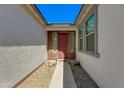 Inviting front entrance with a red door, desert landscaping, and a covered walkway leading to the main entrance at 14188 W Artemisa Ave, Surprise, AZ 85387