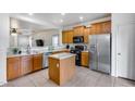 Functional kitchen featuring wooden cabinetry, stainless steel appliances, and an island for efficient food preparation at 15155 W Desert Hills Dr, Surprise, AZ 85379