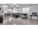 Open living room features neutral tile flooring and a comfortable sectional sofa, perfect for relaxation at 15155 W Desert Hills Dr, Surprise, AZ 85379