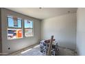 This room is in progress, showing windows, drywall, and construction materials at 15776 W Beryl Ave, Waddell, AZ 85355