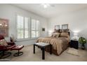 Comfortable bedroom with plantation shutters, ceiling fan, and neutral decor at 15936 W Clear Canyon Dr, Surprise, AZ 85374