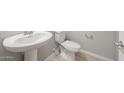 Half-bathroom features a pedestal sink, modern fixtures, and neutral finishes, providing a clean and functional space at 17614 W Palo Verde Dr, Litchfield Park, AZ 85340