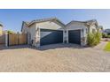 Spacious home with a three-car garage, brick paver driveway, and well-maintained landscaping at 17962 W Elm St, Goodyear, AZ 85395