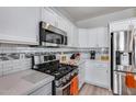 Modern kitchen boasting stainless steel appliances, sleek countertops, white cabinets, and stylish backsplash at 17988 W Deneen Way, Surprise, AZ 85374